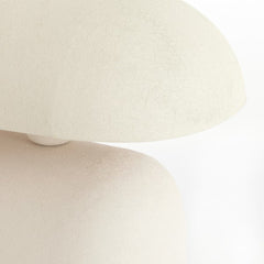 close up image on edge of smooth curved cream table lamp