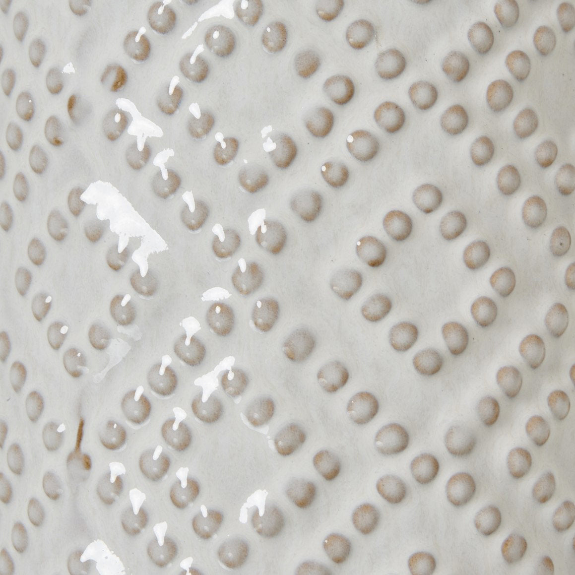 close up image of beaded detail on white ceramic vase