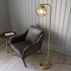 image taken from above of satin brass curved floor lamp with dimpled champagne glass shade