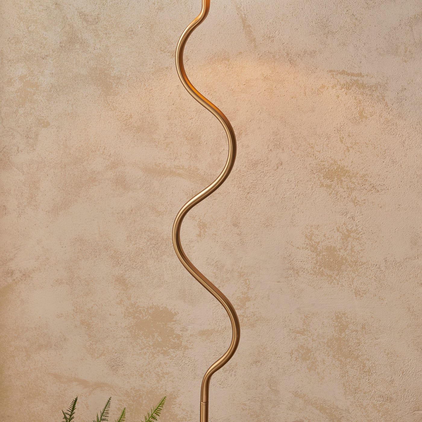 close up on wriggle-shaped body of brass floor lamp