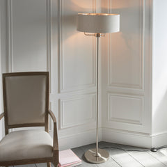 image of chrome-body floor lamp with natural coloured shade propped up by three arms
