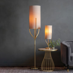image of tall floor lamp next to matching rectangular table lamp emitting warm glow in living room