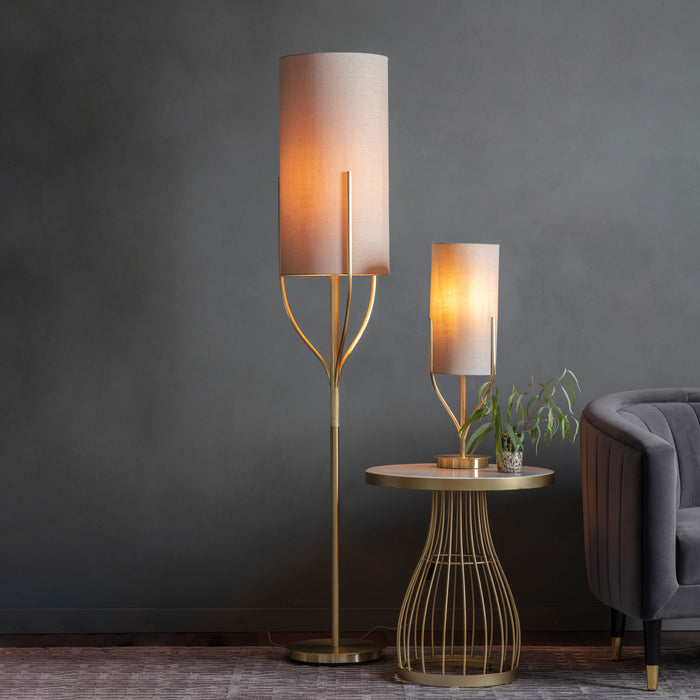 image of tall floor lamp next to matching rectangular table lamp emitting warm glow in living room