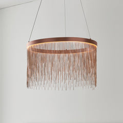 image of brushed copper tasselled ceiling pendant light hanging in front of grey wall
