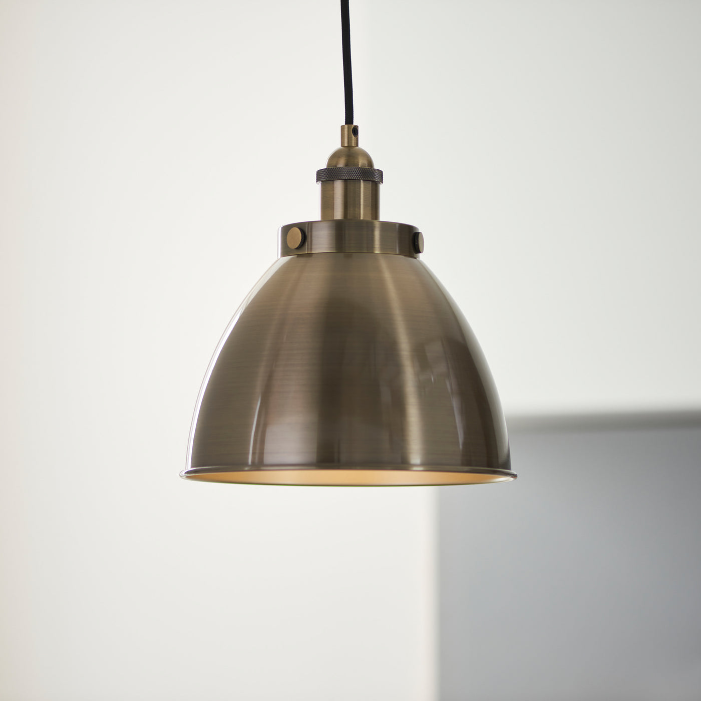 close up image of antique brass pendant light hanging from black cable