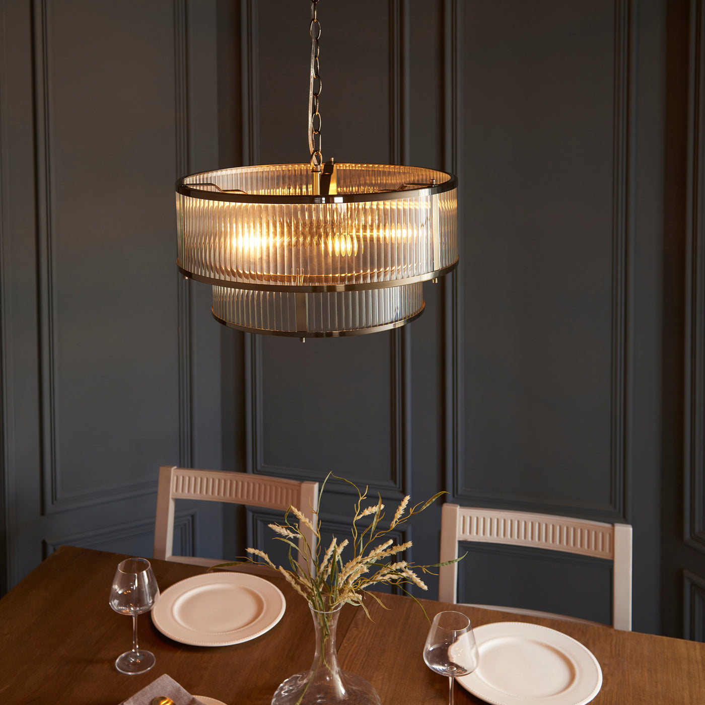 image taken from slightly above of ribbed glass pendant light over a dining table