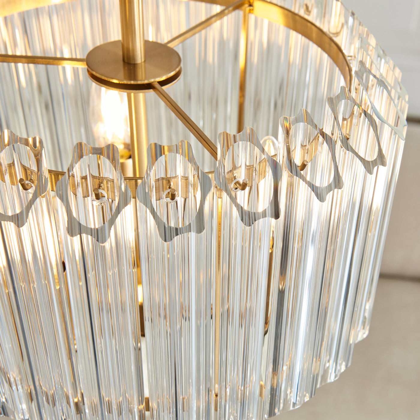 image taken from above of chandelier-type light with glass cylinders and brass fixtures