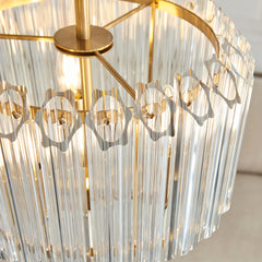 image taken from above of chandelier-type light with glass cylinders and brass fixtures