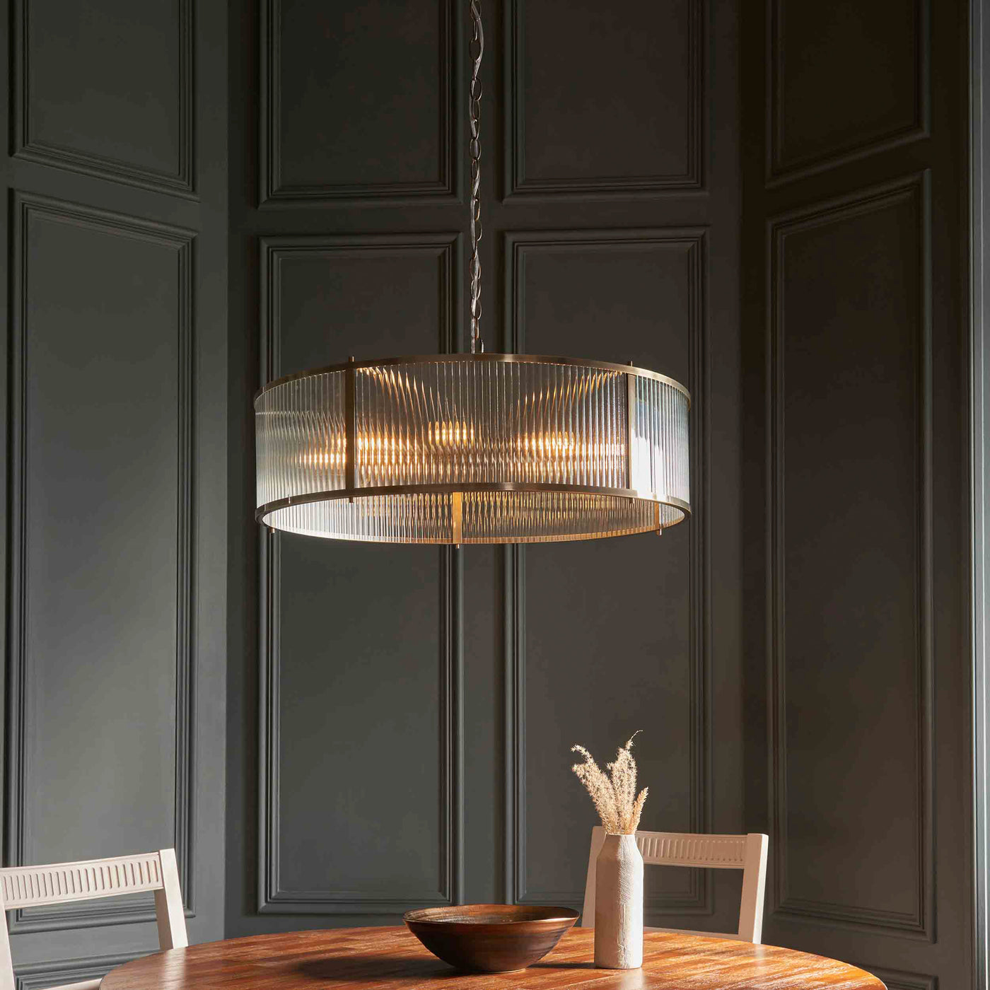 image of 8 pendant light with ribbed glass hanging above dining table
