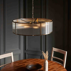 slightly angled image of ribbed glass pendant light emitting warm light from 8 bulbs within