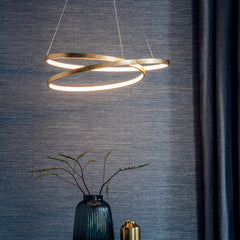 image of gold scribbly pendant light in front of a wood-effect wall