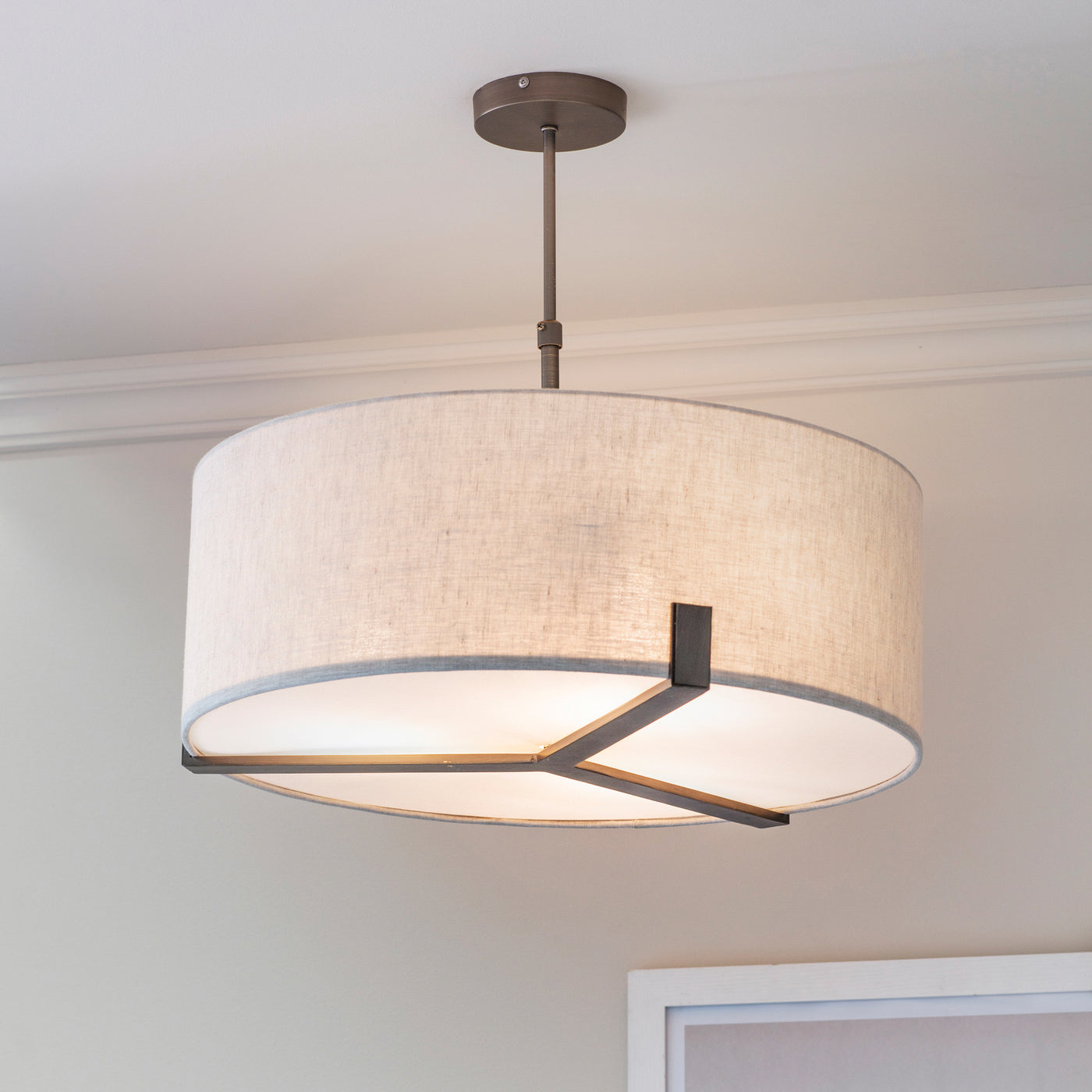 image of linen fabric light shade supported by three-pronged bronze metal framework