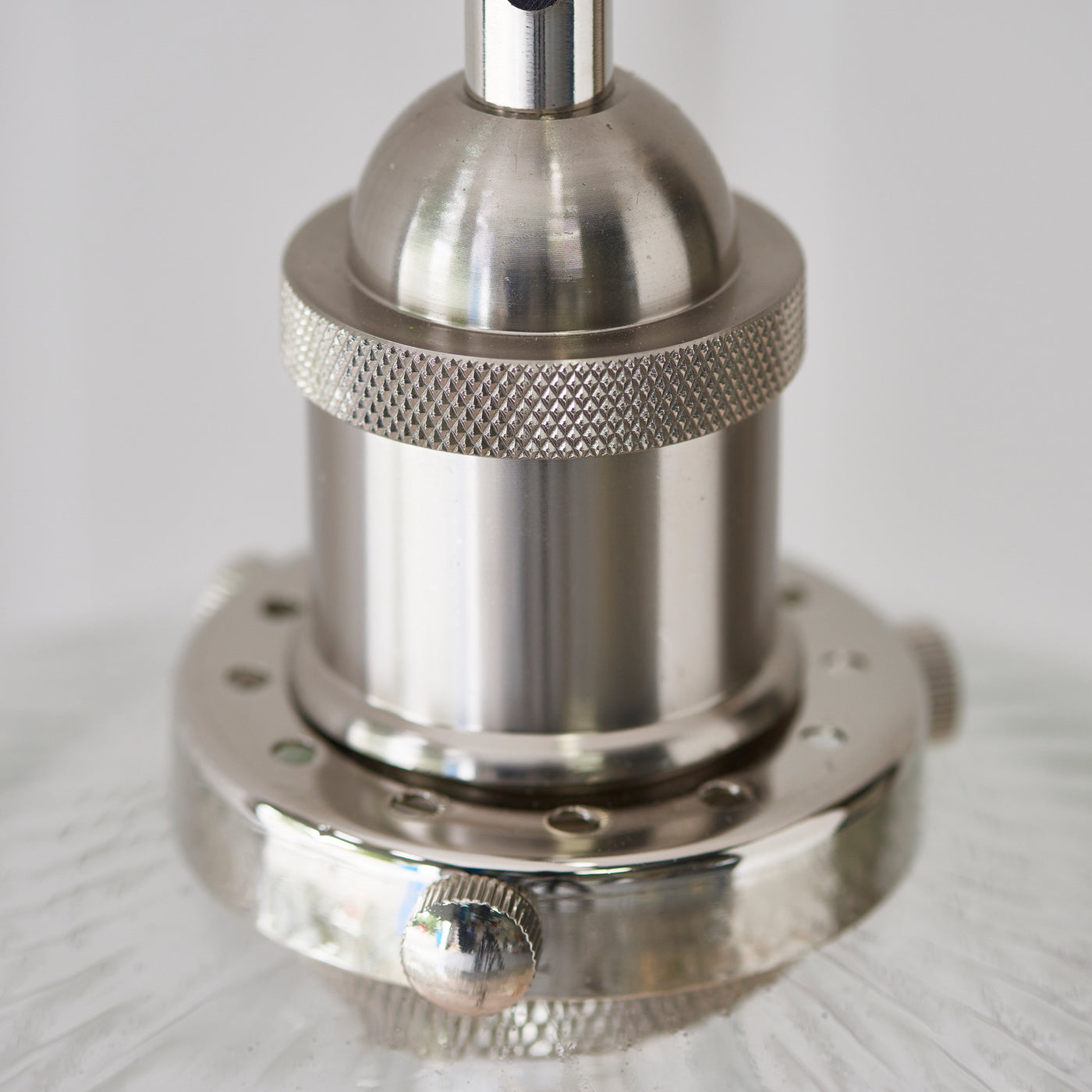 close up image on nickel fixture detail of ribbed glass pendant light shade