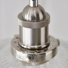 close up image on nickel fixture detail of ribbed glass pendant light shade