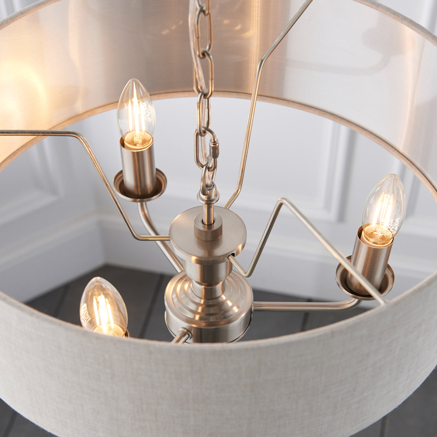 image over the top of ceiling light with beige shade and chrome arms