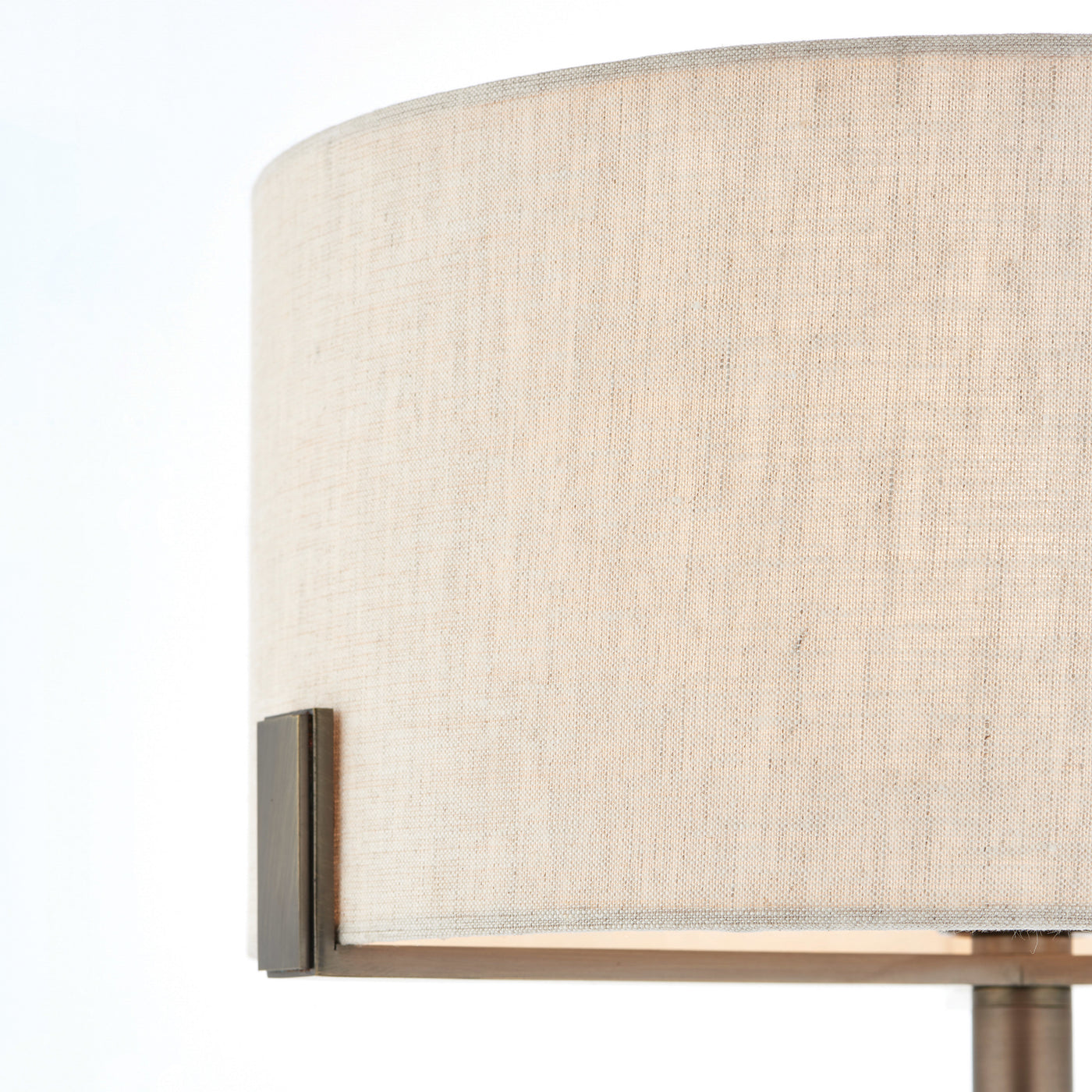 side on close up image of linen shade supported by bronze metalwork arm