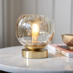 close up on dimpled champagne glass of table light