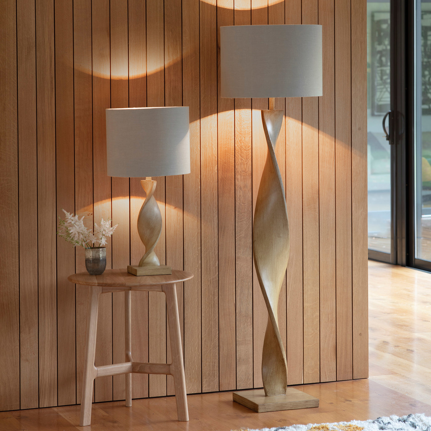 image of two twisted wooden lamps, one table and one floor, next to each other in an entryway