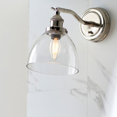 image of wall light with clear glass shade and nickel fixture on a marble-effect kitchen wall