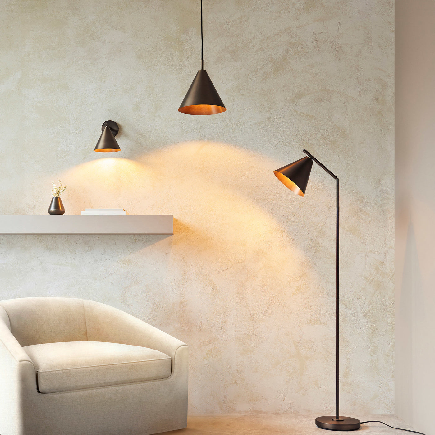 wide image of living room with matching floor lamp, ceiling light and wall light all in antique bronze emitting warm light