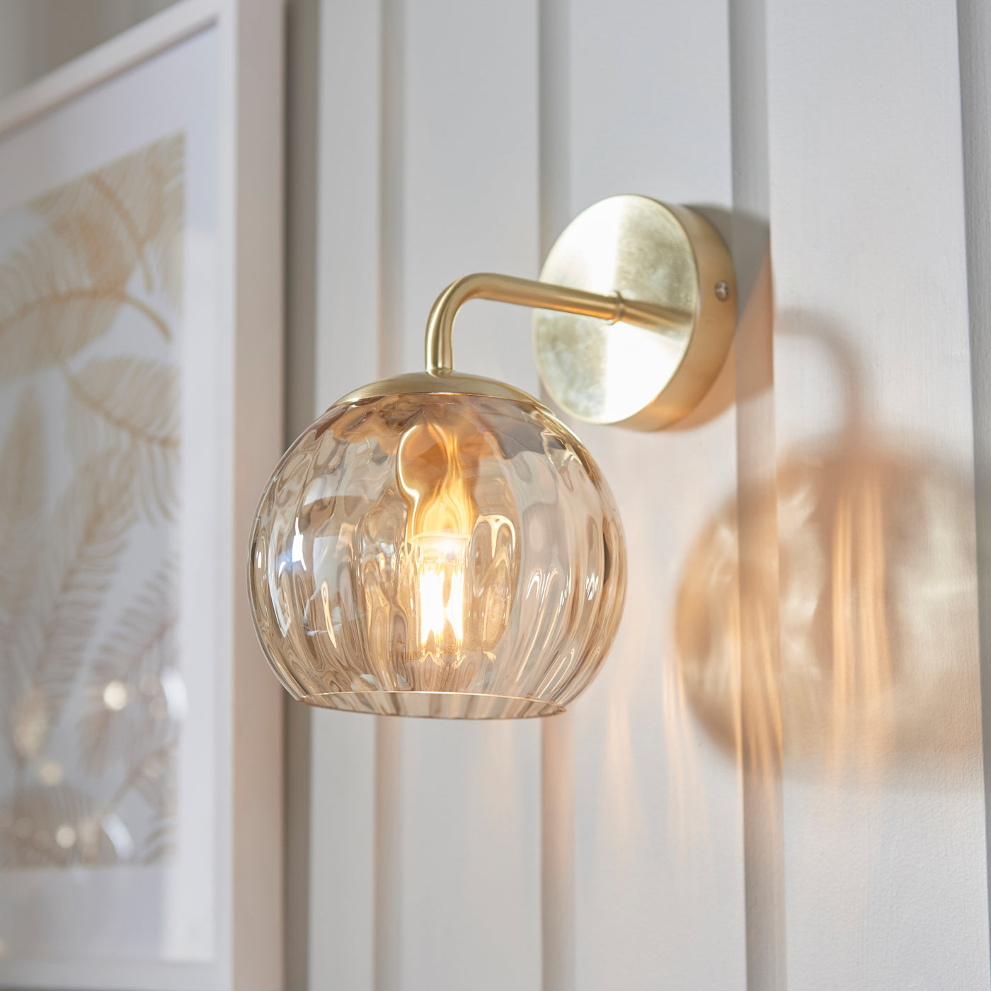 image of dimpled glass champagne wall light on panelled cream wall