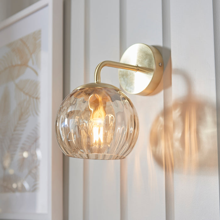 image of dimpled glass champagne wall light on panelled cream wall